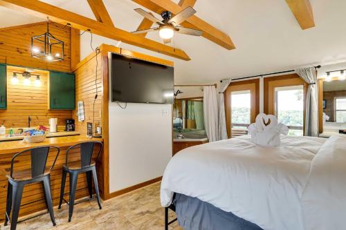 1 dormitorio con 1 cama blanca y cocina en Eureka Springs Cabin Rental about 5 Mi to Beaver Lake! en Garfield
