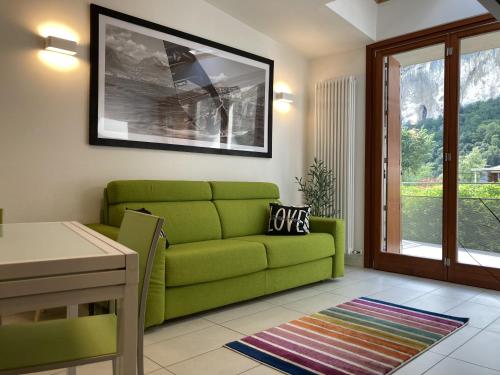 a living room with a green couch and a table at Outdooredo Garda Torbole in Nago-Torbole