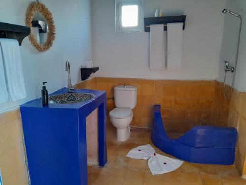 La salle de bains est pourvue d'une table bleue et de toilettes. dans l'établissement Wave Mogador, à Essaouira