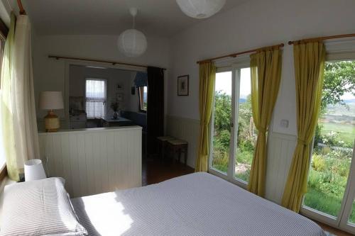 a bedroom with a bed and a large window at Innisfreedom cabin in Sligo