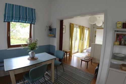 a living room with a table and blue chairs at Innisfreedom cabin in Sligo