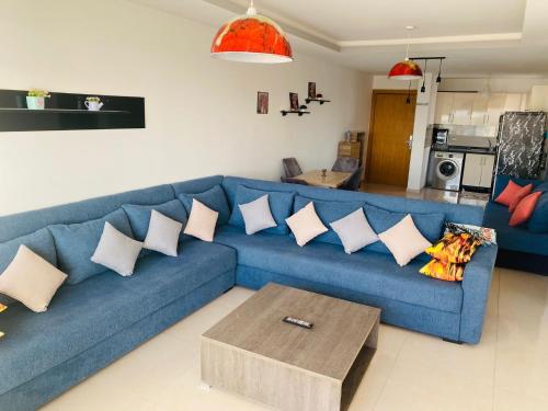 a blue couch with pillows in a living room at Beach and Mountain View Surf Apartment in Aourir
