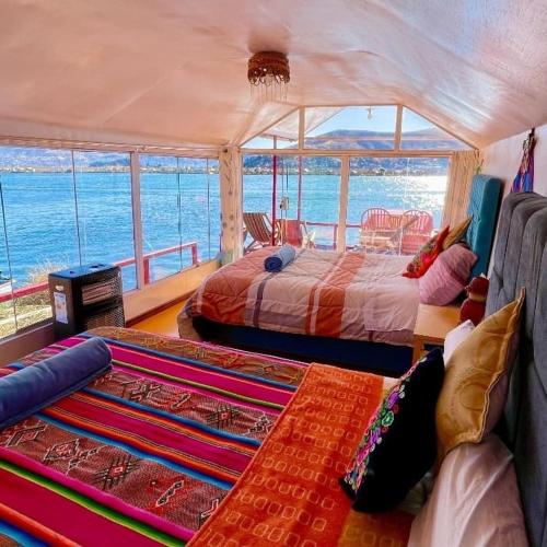 a bedroom with two beds and a view of the ocean at Uros TITICACA home lodge in Puno