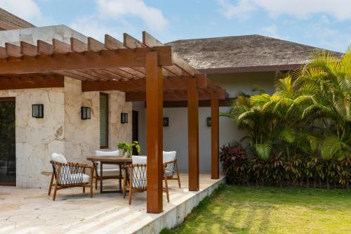 a patio with a wooden pergola in front of a house at Fairmont Mayakoba in Playa del Carmen