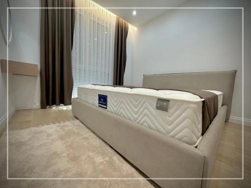 a bedroom with a mattress on a couch in front of a window at Luxury Apartment - San Pietro in Durrës