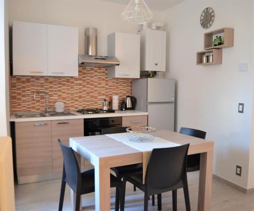 eine Küche mit Tisch und Stühlen und einem Kühlschrank in der Unterkunft Malcesine with Charme - Family&friends Superior 2 bedrooms apartment in Malcesine