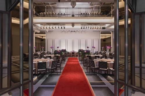 a dining room with tables and chairs and a red carpet at Taipei Marriott Hotel in Taipei