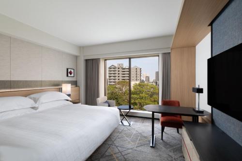 東京にあるシェラトン都ホテル東京のベッド、デスク、窓が備わるホテルルームです。