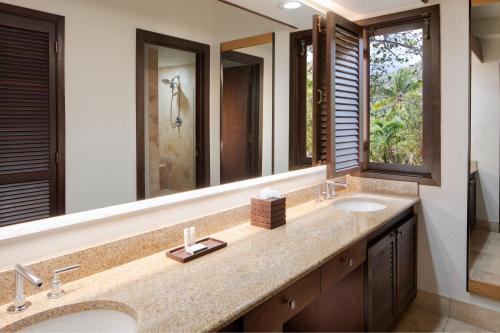 a bathroom with two sinks and a large mirror at Carambola Beach Resort St. Croix, US Virgin Islands in North Star