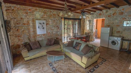 a living room with two couches and a table at Stone Made Private Pool Villas Kriopigi in Kriopigi