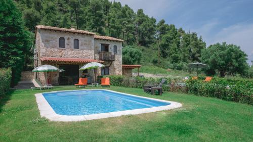 a country house with a swimming pool in the yard at Stone Made Private Pool Villas Kriopigi in Kriopigi
