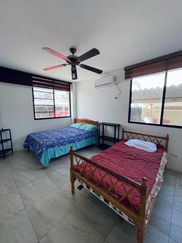 a bedroom with two beds and a ceiling fan at Departamento hermoso frente a chipipe in Salinas