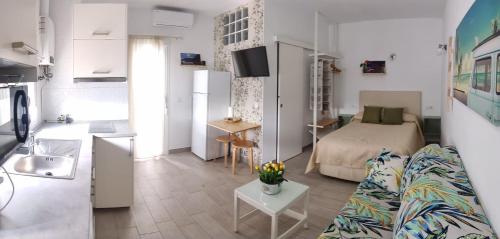 a living room with a couch and a bed and a kitchen at Estudio Patio San Paulino in Barbate