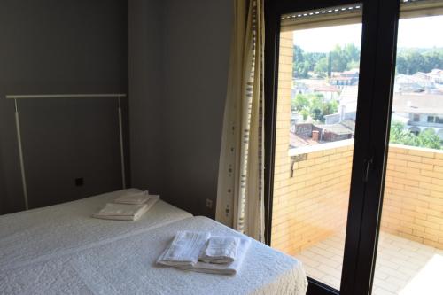 a bedroom with a bed and a large window at São Roque Hotel & Suites in Bragança