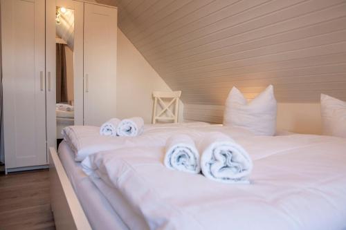 ein weißes Bett mit Handtüchern darüber in der Unterkunft Ferienwohnung 'Haus Ingeborg, Wohnung 1/EG' in Cuxhaven