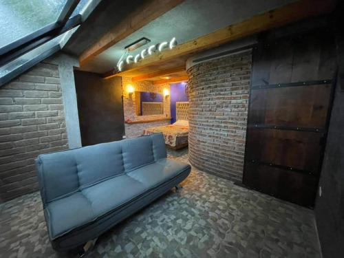 a couch in a room with a brick wall at MANDALA CAMP in Tomatlán