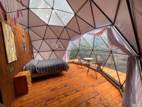 - une chambre dans une tente avec un lit et une table dans l'établissement MANDALA CAMP, à Tomatlán