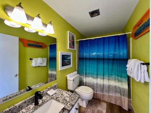 a bathroom with a toilet and a sink and a mirror at Sandpiper Cove 8224 in Destin