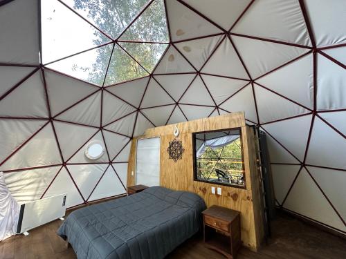 a bedroom in a dome tent with a bed and a window at MANDALA CAMP in Tomatlán