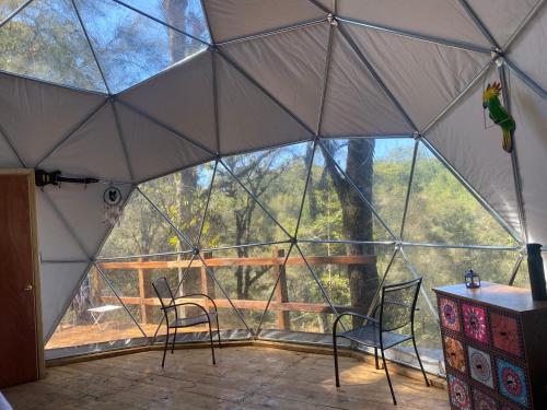 an inside of a tent with two chairs and a table at MANDALA CAMP in Tomatlán