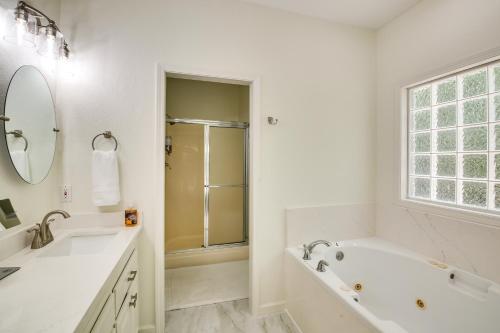 a white bathroom with a tub and a sink and a shower at Hot Springs Village Golf Getaway with Deck! in Hot Springs Village