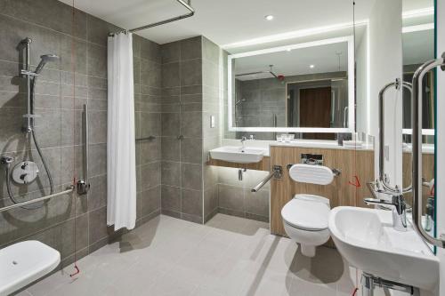 a bathroom with a toilet and a sink and a shower at Courtyard by Marriott Stoke on Trent Staffordshire in Newcastle under Lyme