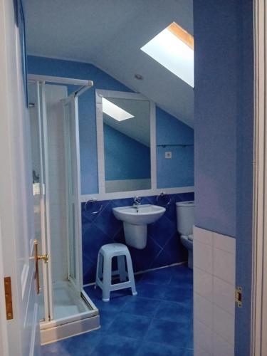 bagno blu con lavandino e servizi igienici di Casa Los Lomas ad Arenas de Iguña