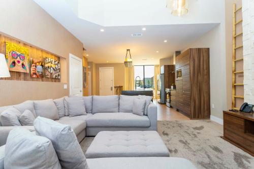 a living room with a white couch and a kitchen at Magical 4suites Home w jacuzzi near Disney 7497 in Orlando