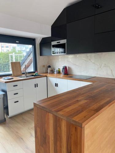 uma cozinha com armários brancos e um balcão de madeira em Spacious app/Antwerp city center #003 em Antuérpia