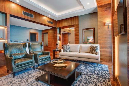 a living room with a couch and a table and chairs at Sheraton Grand Samsun Hotel in Samsun