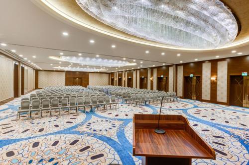 an auditorium with a large room with chairs and a stage at Sheraton Grand Samsun Hotel in Samsun