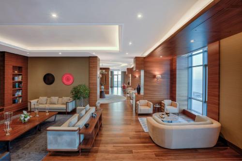 a large living room with a large couch and tables at Sheraton Grand Samsun Hotel in Samsun