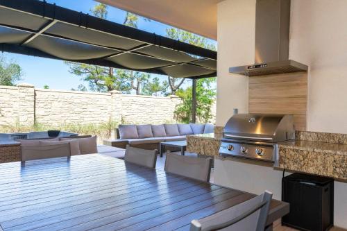 a patio with a grill and a table and chairs at Magical 4suites Home w jacuzzi near Disney 7497 in Orlando