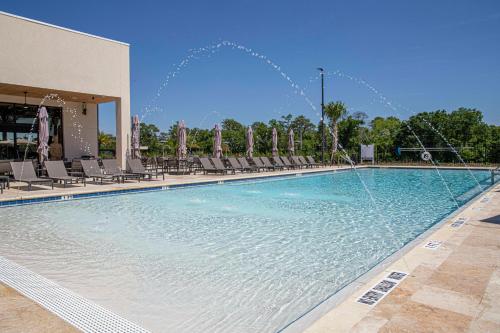 a large swimming pool with water fountains at Magical 4suites Home w jacuzzi near Disney 7497 in Orlando