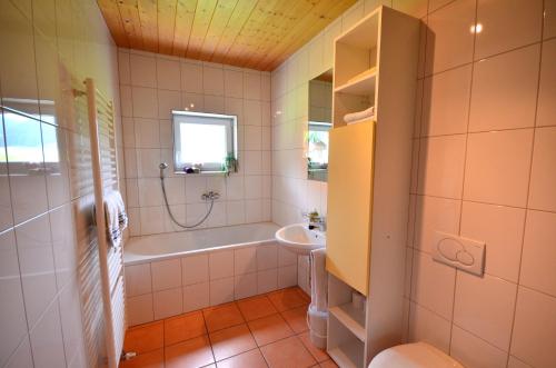een badkamer met een bad en een wastafel bij Apartment Magdalena in Bezau