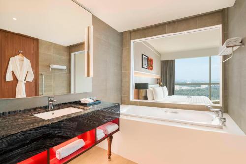 布城的住宿－普特拉賈亞艾美度假酒店，一间带浴缸和大镜子的浴室