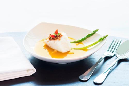 a plate of food on a table next to a fork and knife at Le Meridien Putrajaya in Putrajaya