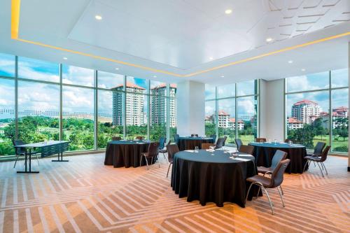 a conference room with tables and chairs and large windows at Le Meridien Putrajaya in Putrajaya