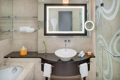 a bathroom with a sink and a tub and a mirror at Grand Hotel River Park, a Luxury Collection Hotel, Bratislava in Bratislava