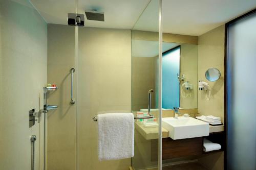 a bathroom with a sink and a shower with a mirror at Four Points by Sheraton Ahmedabad in Ahmedabad