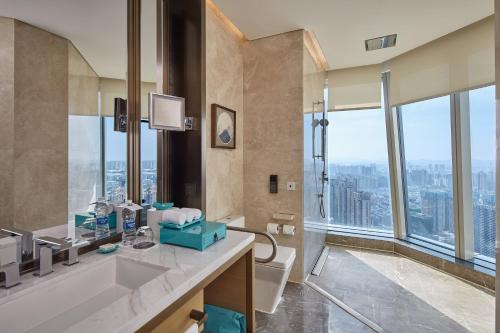 a bathroom with a shower and a sink and a toilet at Meixi Lake Hotel, a Luxury Collection Hotel, Changsha in Changsha