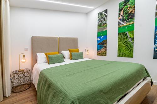 une chambre avec un grand lit avec une couverture verte dans l'établissement Foral Dreams, à Fajã de Cima