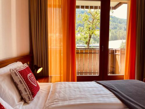 a bedroom with a bed and a window with a view at Elga Residence - Relax in Alta Valtellina - Bormio in Valdisotto
