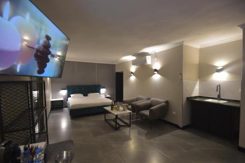 a hotel room with a bed and a flat screen tv at מלון הברון in Ramat Eliyyahu