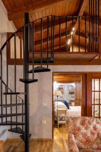 a spiral staircase in a room with a bedroom at Blerina's Agritourism Concept in Laknas