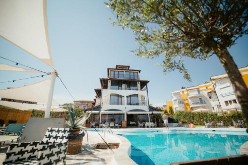 Relax Sozopol في سوزوبول: مسبح الفندق بمبنى في الخلف