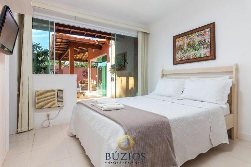 a bedroom with a large bed and a window at BZ36 Casa com piscina privativa - Centro de Búzios in Búzios