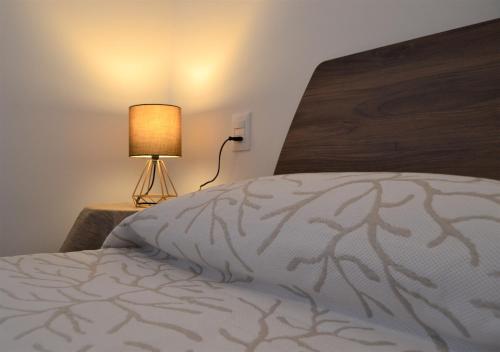 Schlafzimmer mit einem Bett und einer Lampe auf einem Tisch in der Unterkunft Malcesine with Charme - Family&friends Superior 2 bedrooms apartment in Malcesine