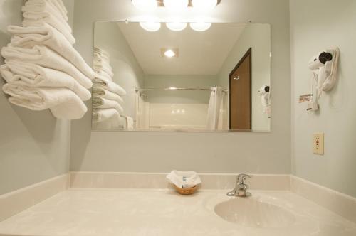 a white bathroom with a sink and a mirror at Venture Inn in Libby