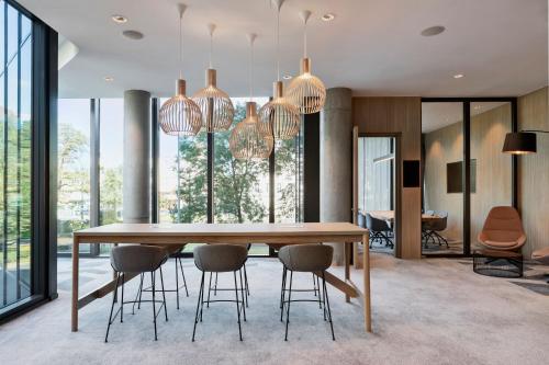 a dining room with a wooden table and chairs at Courtyard by Marriott Szczecin City in Szczecin